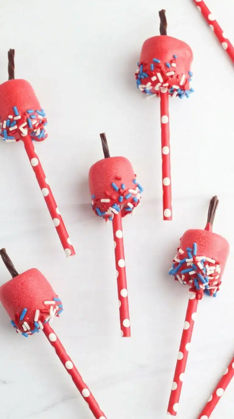 4th Of July Marshmallow Pops with patriotic sprinkles on striped paper straws