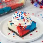 4th of July red white and blue cheesecake bars with Oreo crust and whipped cream
