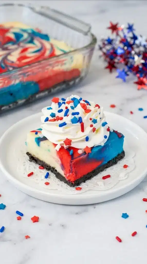 4th of July red white and blue cheesecake bars with Oreo crust and whipped cream