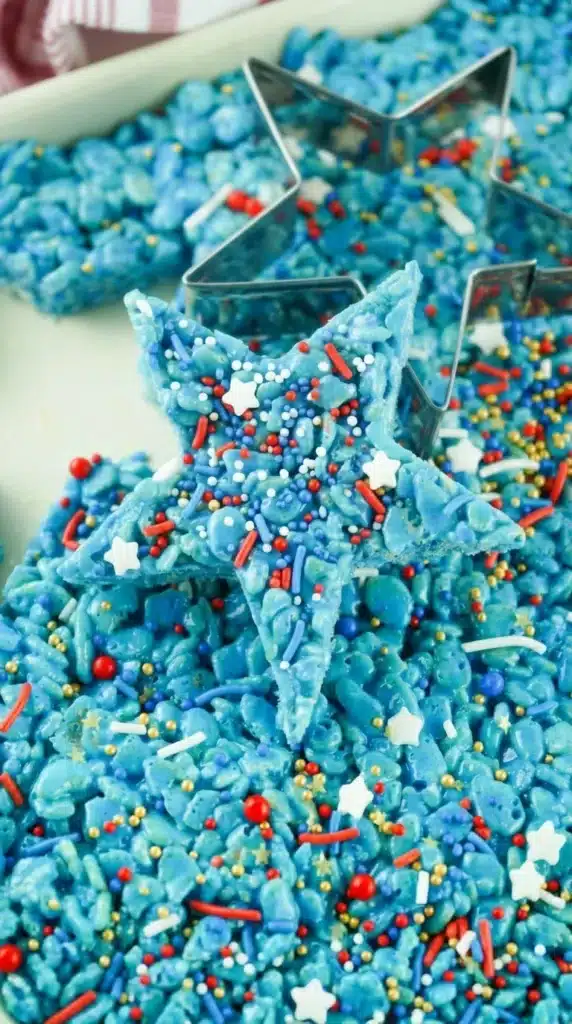 4th Of July Rice Krispie Treats That Everyone Loves 9 4th Of July Rice Krispie Treats cut into blue star shapes with patriotic sprinkles