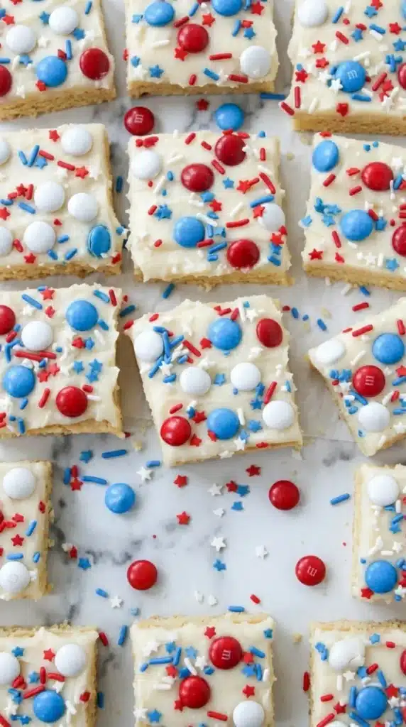 4th of July sugar cookie bars with vanilla frosting and patriotic sprinkles