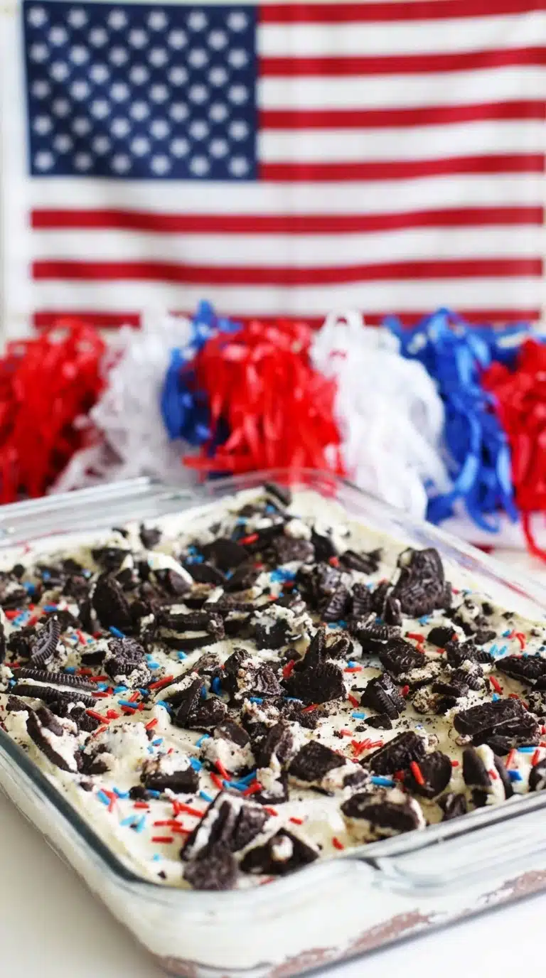 No bake Oreo cheesecake bars with sprinkles and crushed cookies in a baking dish