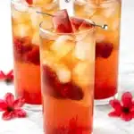 Bellini Peach Raspberry Iced Tea with fresh peaches, raspberries, and ice in a tall glass