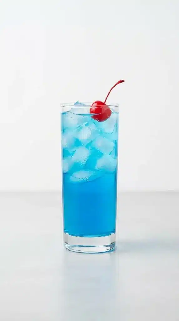 Fourth of July Cocktail in tall glass with blue drink and cherry garnish