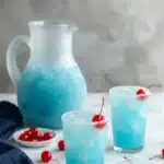 Blue Hawaiian Lemonade in icy glasses with cherries and frosted pitcher