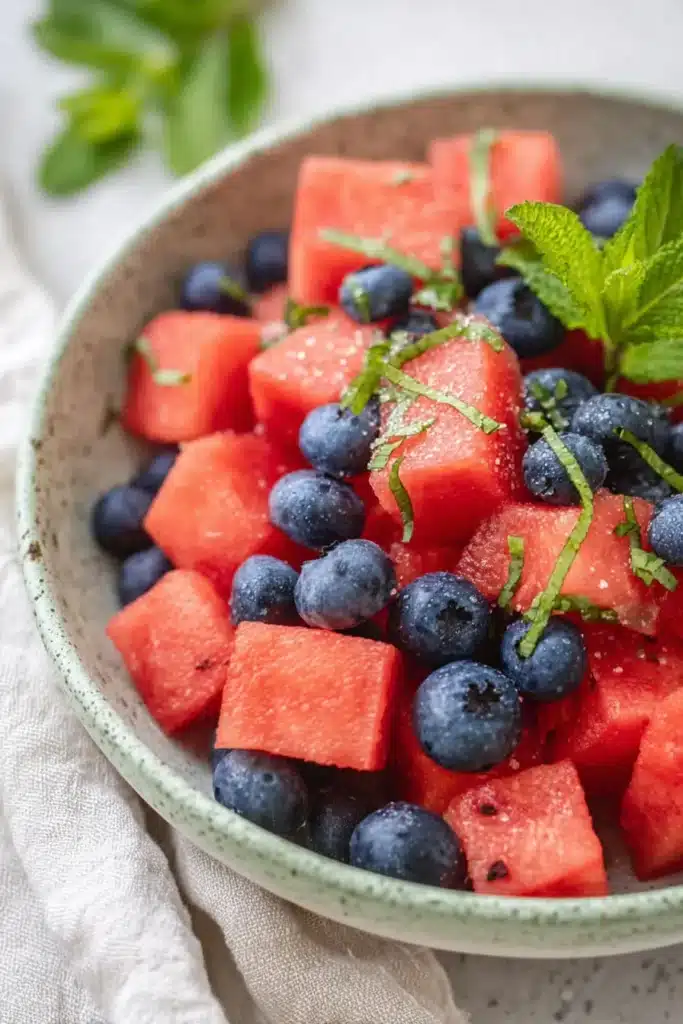 Close up Watermelon Blueberry Salad with fresh mint in a ceramic serving bowl