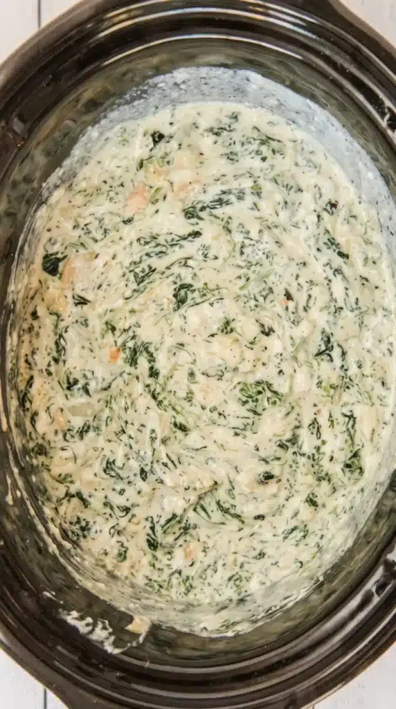 Creamy Crockpot Spinach Artichoke Dip Recipe cooking inside a slow cooker