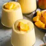 Creamy mango smoothie recipe served in cups with fresh mango topping