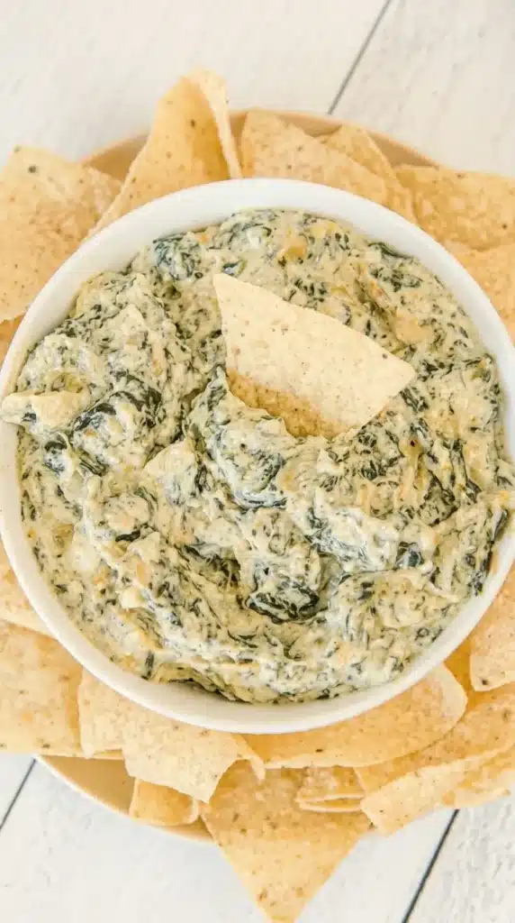 Creamy crockpot spinach artichoke dip served with crispy tortilla chips