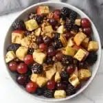 Fall fruit salad with apples, grapes, blackberries, pecans, and cinnamon dressing