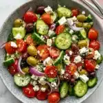 Fresh Greek salad recipe with cucumber, tomatoes, olives, feta cheese, and homemade dressing