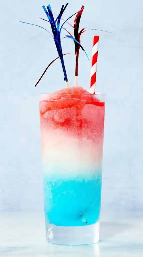 Frozen Bomb Pop Cocktail with red slushy top and popsicle garnish