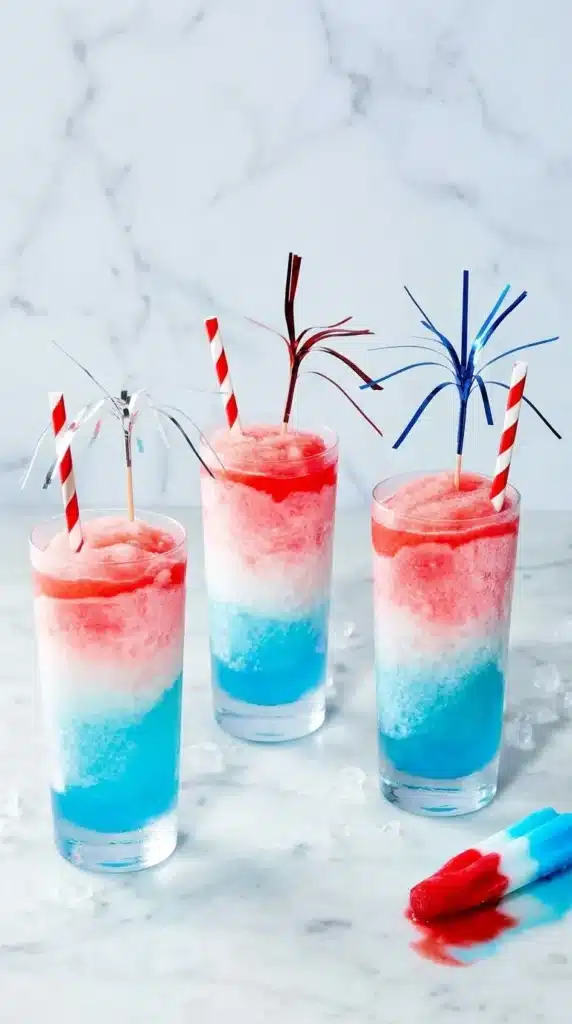 Frozen Bomb Pop Cocktail drinks with layered red white and blue slushy texture for party serving