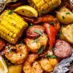 Grilled shrimp boil in foil packets with sausage, corn, potatoes, and Cajun seasoning