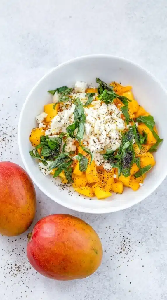 Mango and feta salad with basil and olive oil in a bowl