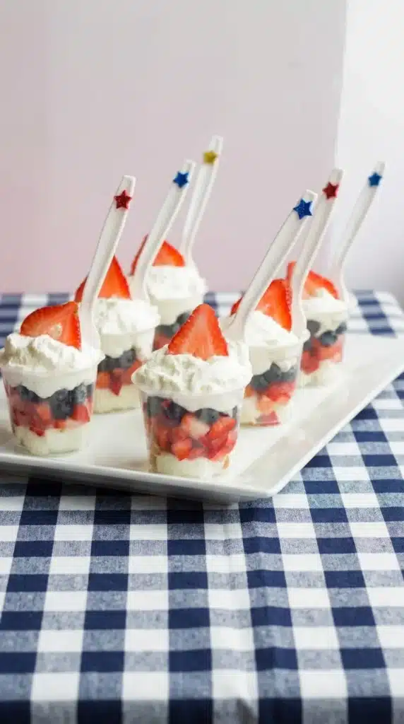 Mini Shortcake Cups with strawberries, blueberries, whipped cream, and patriotic party spoons