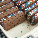 Patriotic mini ice cream sandwiches with red white and blue sprinkles in a baking dish