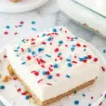Patriotic no bake cheesecake with red white and blue sprinkles on a graham cracker crust