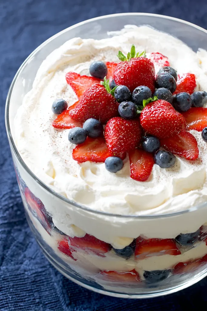 Patriotic Trifle Dessert topped with whipped cream strawberries and blueberries