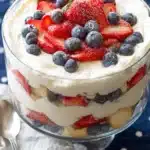 Patriotic trifle dessert with strawberries, blueberries, whipped cream, and cake layers