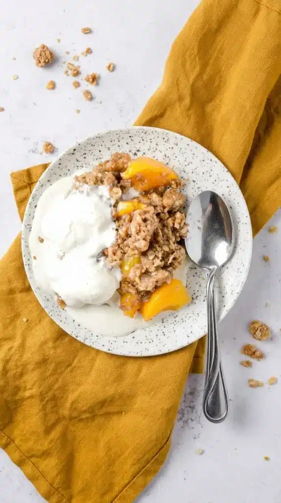 Peach Crisp with Canned Peaches topped with melting vanilla ice cream