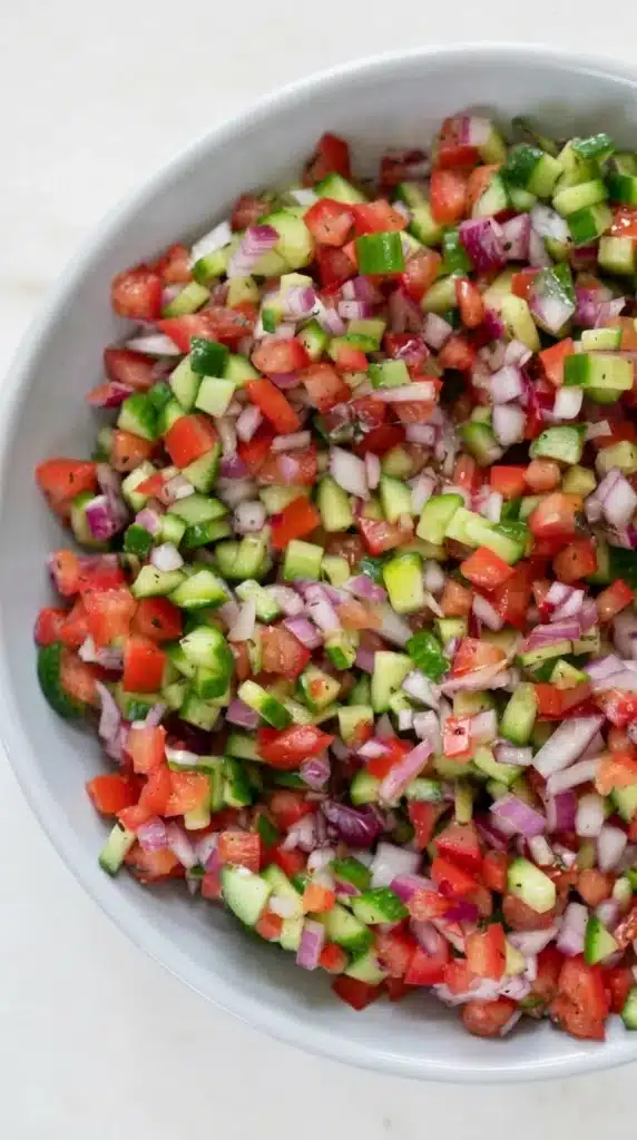 Persian Shirazi Salad with diced cucumber, tomato, and red onion in a white bowl