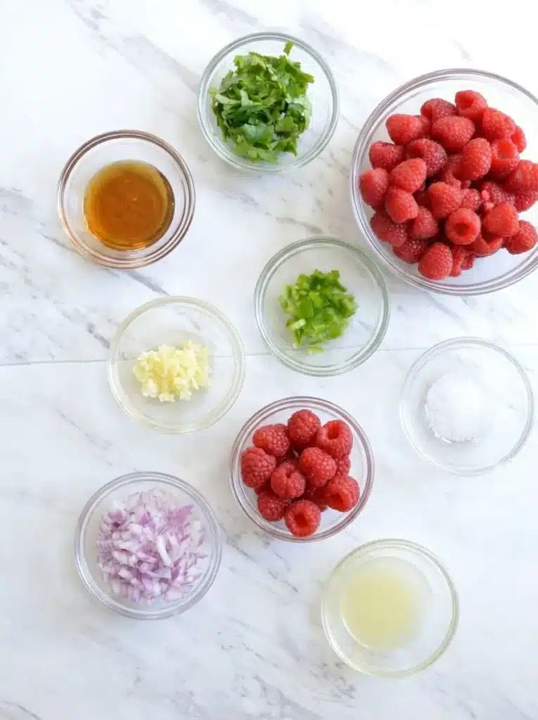 Raspberry Salsa ingredients arranged in bowls on a stone surface