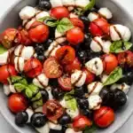 Red White and Blue Caprese Salad with tomatoes, blueberries, mozzarella, basil, and balsamic glaze