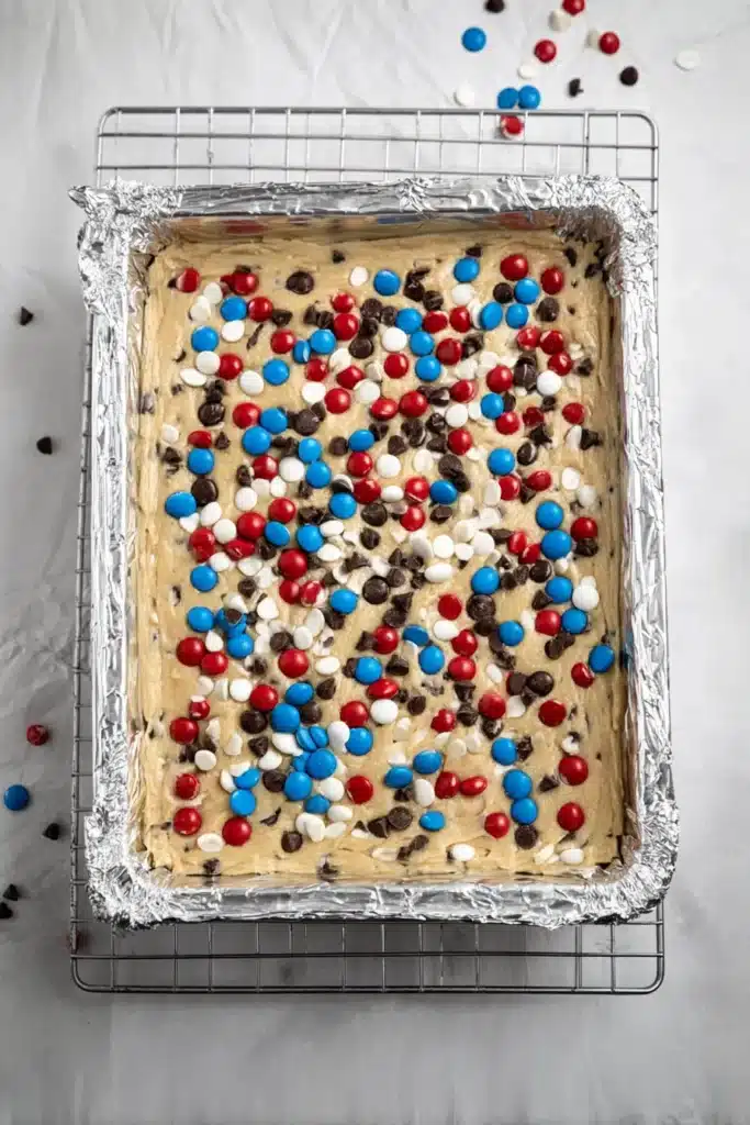 Red, White and Blue M&M’S Cookie Bars dough in baking pan before baking