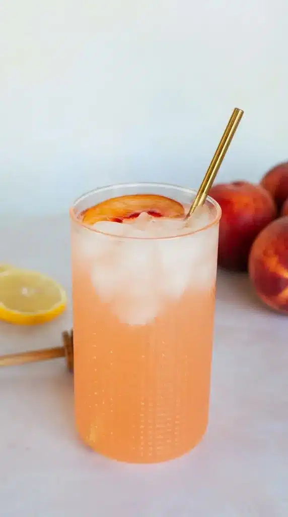 Refreshing peach lemonade in tall glasses with ice and peach slices