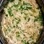 Slow cooker cilantro lime chicken with shredded chicken and fresh cilantro in savory lime broth