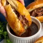 Slow Cooker French Dip sandwich dipped in rich au jus with melted provolone cheese