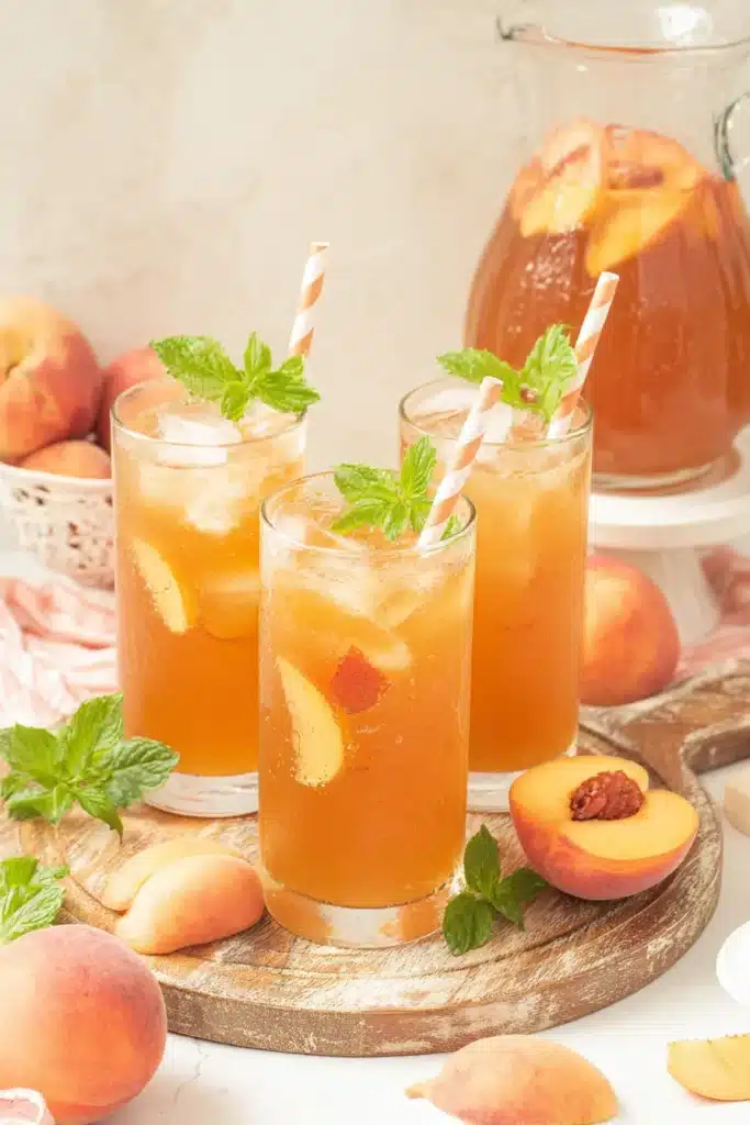 Southern Peach Tea served with fresh peaches and mint in summer drink glasses