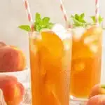Southern Peach Tea with fresh peaches, mint, and ice in tall summer drink glasses