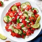 Strawberry watermelon cucumber salad with feta and mint in a bleu dark plate
