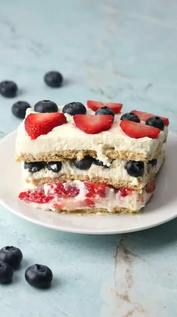 Summer Berry Icebox Cake layered with cream strawberries and blueberries in dish