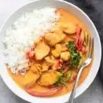 Thai chicken curry with coconut milk served with rice in a rustic bowl