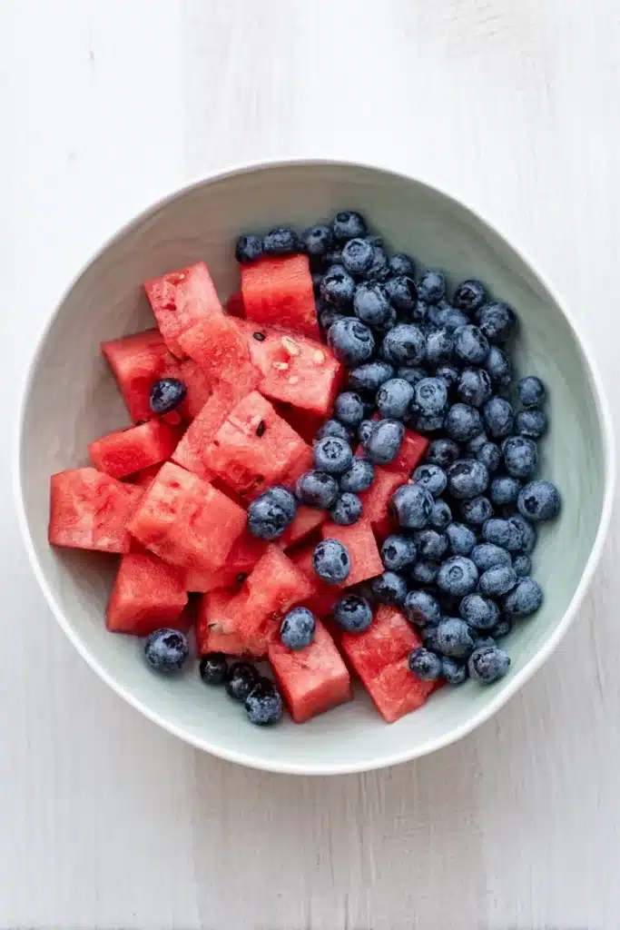 Watermelon Blueberry Salad ingredients in a ceramic bowl on a light summer background