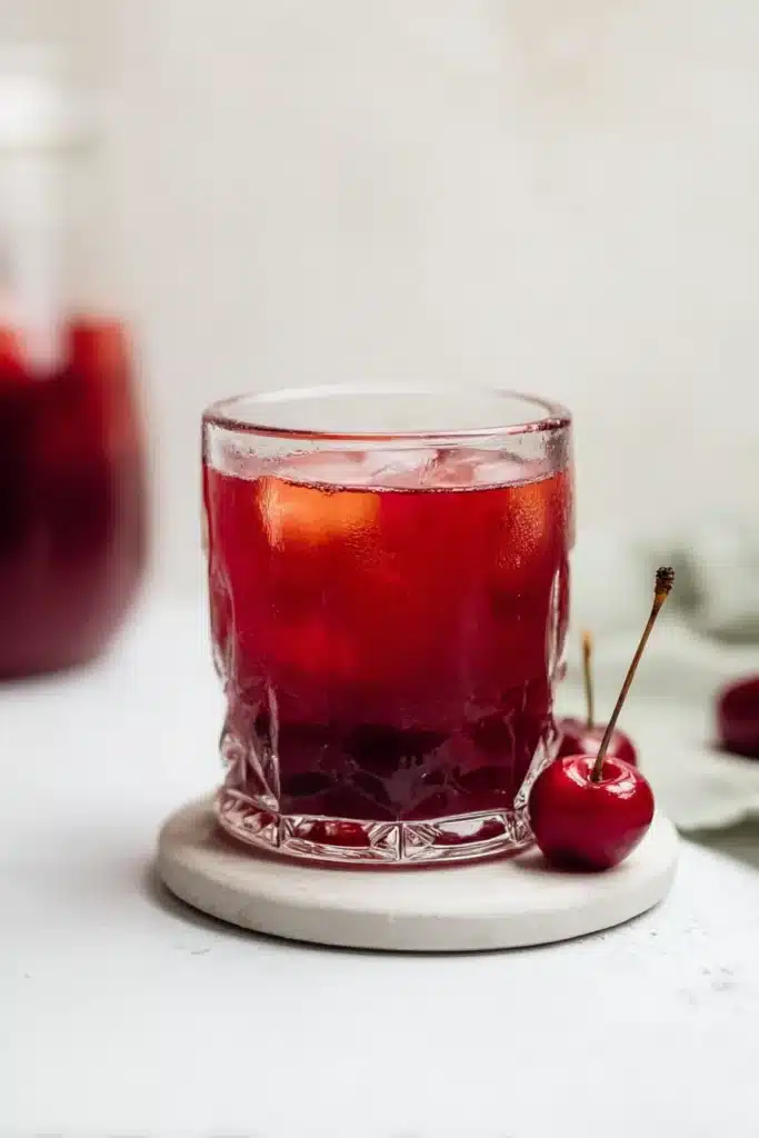 Cherry Pie Iced Tea in a glass over ice with fresh cherry garnish
