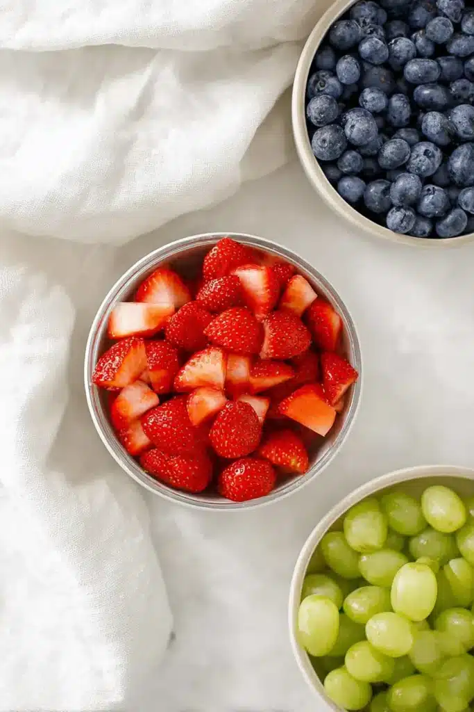Honey Lime Fruit Salad ingredients with strawberries, blueberries, and green grapes