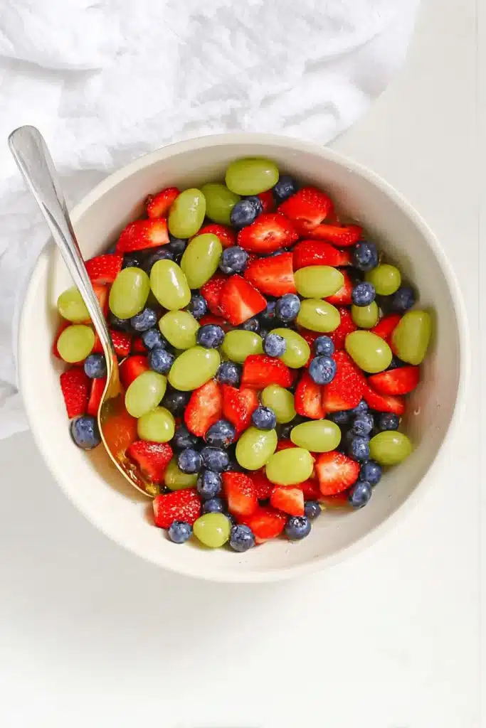 Honey Lime Fruit Salad tossed with strawberries, blueberries, and green grapes