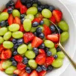Honey Lime Fruit Salad with strawberries, blueberries, and green grapes in a serving bowl