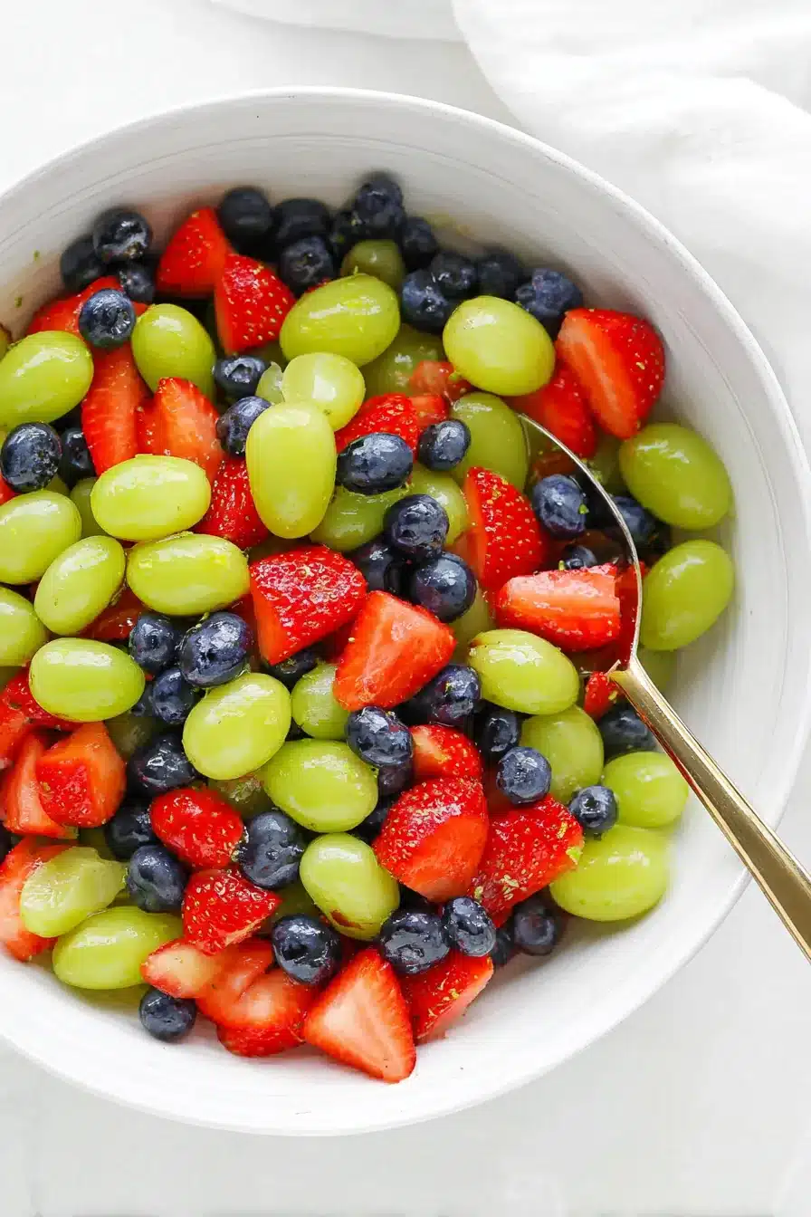 Honey Lime Fruit Salad with strawberries, blueberries, and green grapes in a serving bowl