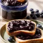 Blueberry Butter Recipe: Amazing Easy Breakfast Spread 9 Blueberry butter spread on toast beside a jar of homemade blueberry fruit butter