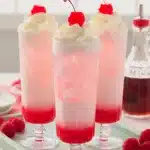 Italian Cream Soda Recipe | Amazing Easy Summer Treat 7 Italian Cream Soda with whipped cream, cherries, and pink syrup in tall glasses