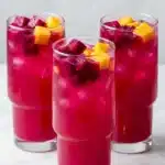 Mango Dragon Fruit Refresher poured over ice with dragon fruit pieces