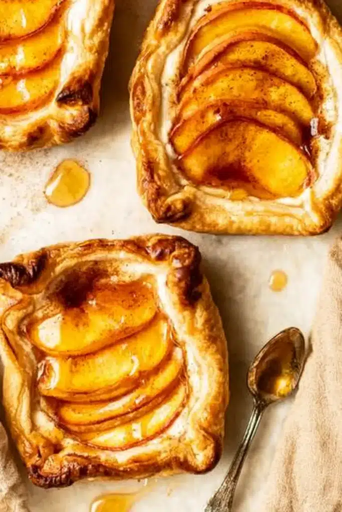 Mini peach and cream cheese tarts topped with peaches and honey drizzle