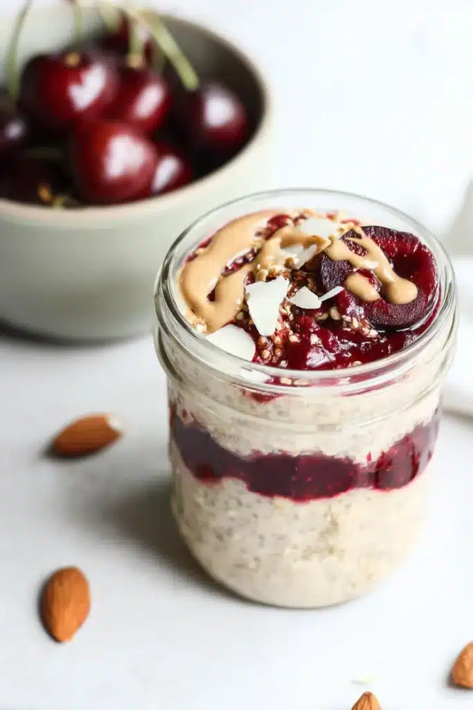 Oats with Cherry Chia Easy Amazing Breakfast Recipe 6 Layered Oats with Cherry Chia in a glass jar with almond butter topping