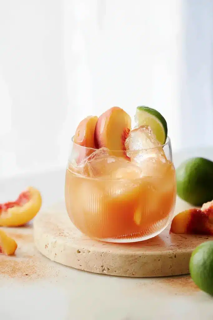 Peach Moscow Mule cocktails with peach and lime garnishes over ice