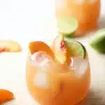 Peach Moscow Mule cocktail with fresh peach, lime, and ice